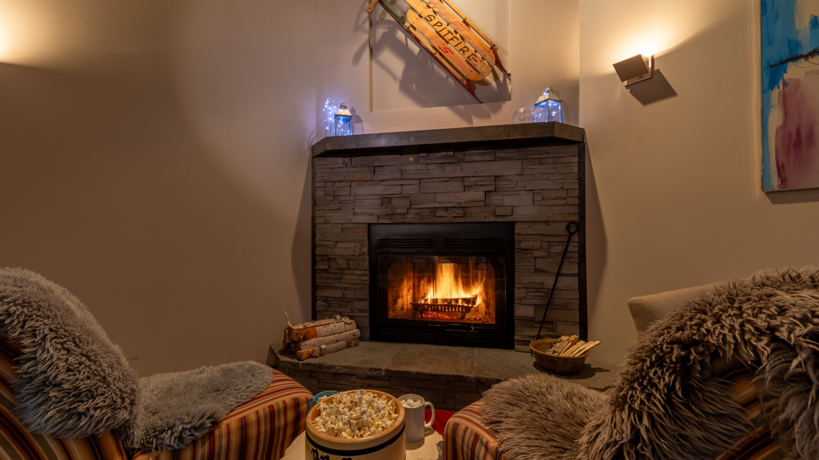 Armchairs in front of a lit fireplace at Moonraker Mountain Mokki